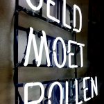 Verlichte neonletters op een zwarte achtergrond met de tekst "Geld Moet Rollen". Elegant en modern design.