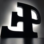 Zwarte letters "E" en "P", silhouet met een witte achtergrond, verlicht van achteren. Minimalistisch en modern ontwerp.